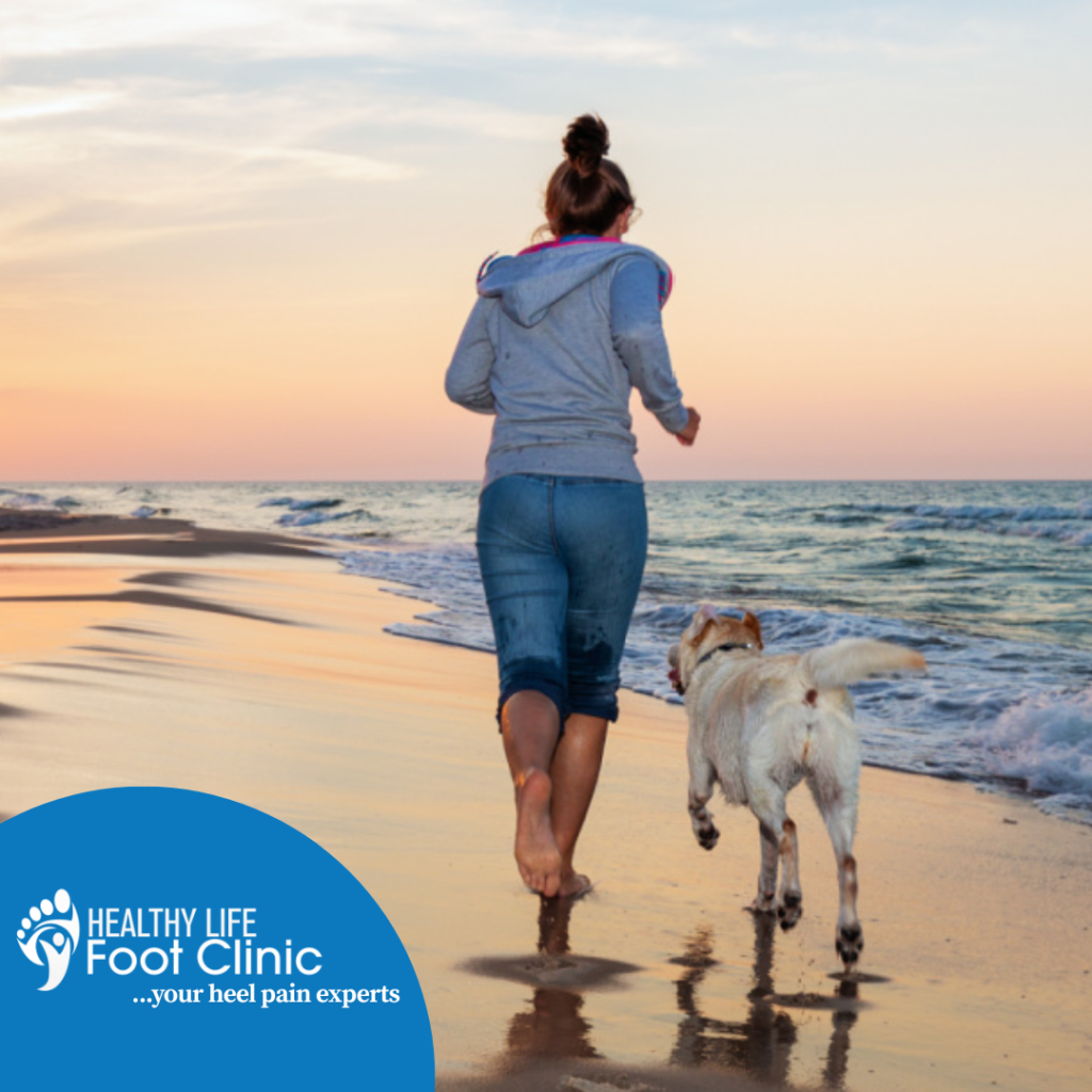Woman Running Along Beach with Dog