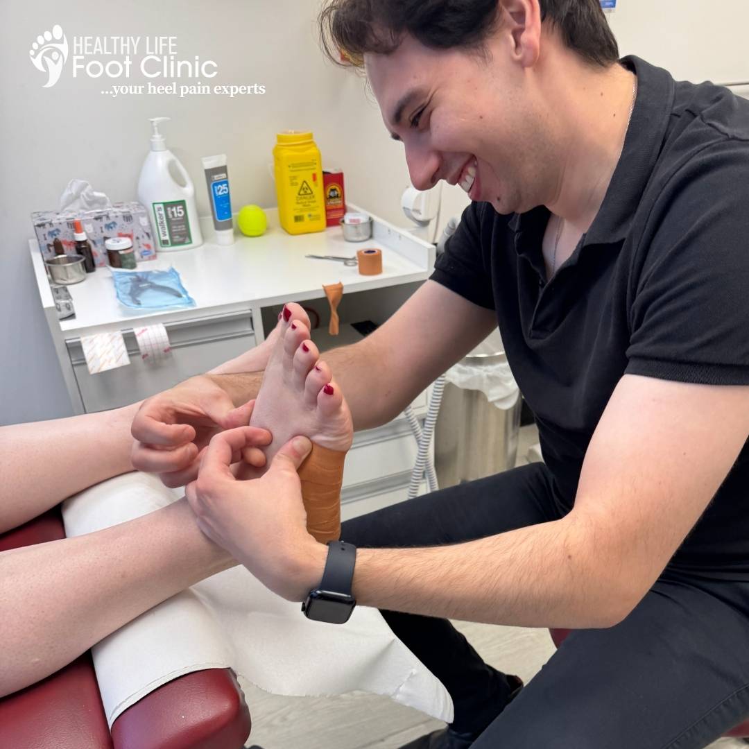 Adelaide Podiatrist, Nick Bourlotos, using low dye taping to support the arch of a patient's foot